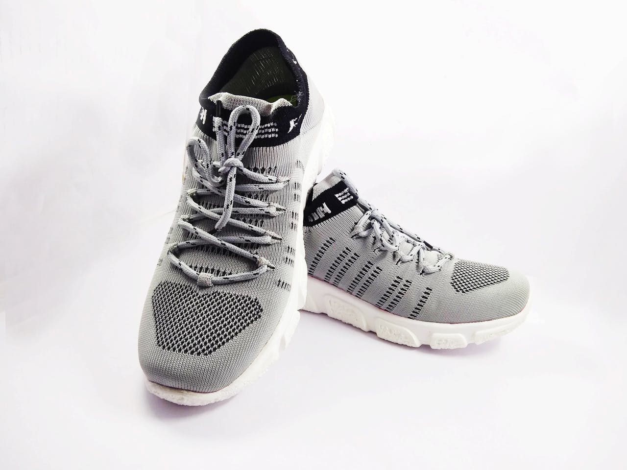 Detailed close-up of stylish grey sneakers, perfect for sports and casual wear on a white background.